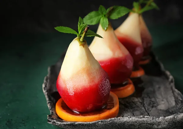 Delicious poached pears in red wine with orange slices on plate — Stock Photo, Image