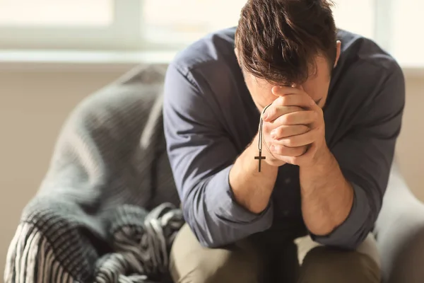 Religious young man praying to God at home — Stock Photo, Image