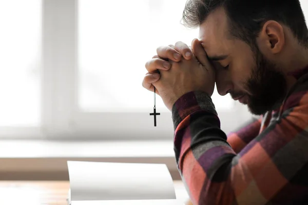 Religious young man praying to God at home — Stock Photo, Image