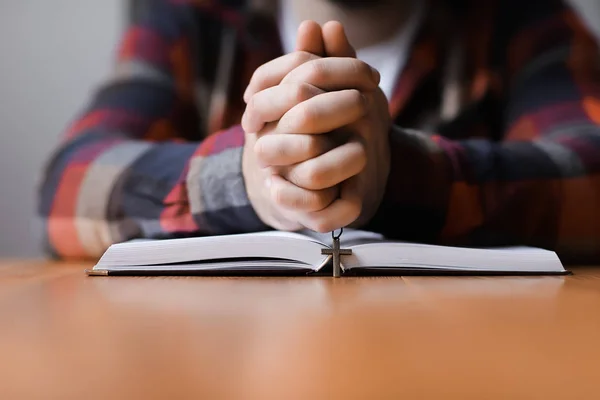 Religieuze jongeman met Bijbel bidden thuis, close-up — Stockfoto