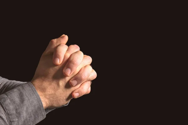 Mani di religiosi che pregano su sfondo nero — Foto Stock
