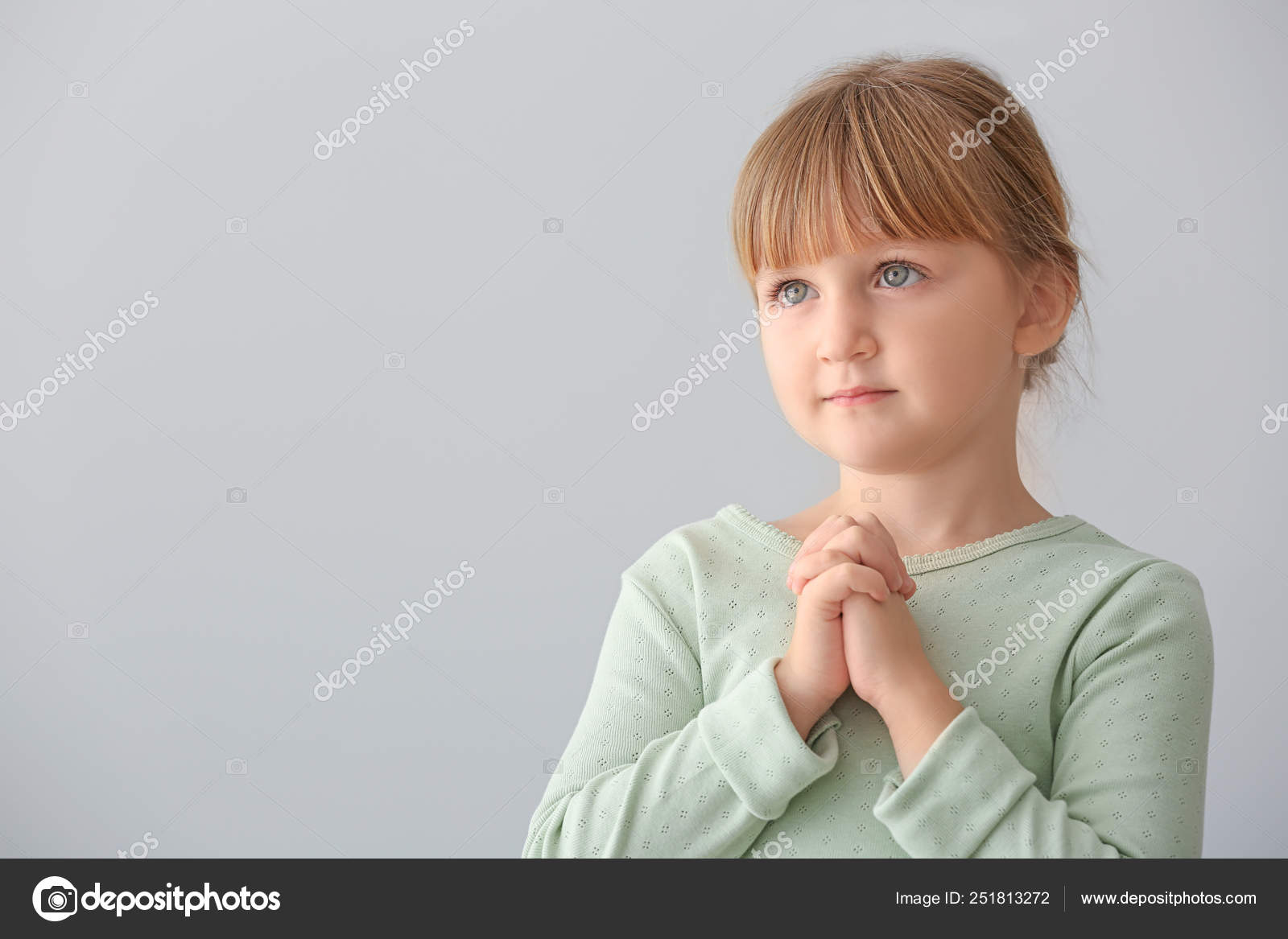 Little girl praying on light background Stock Photo by ©serezniy 251813272