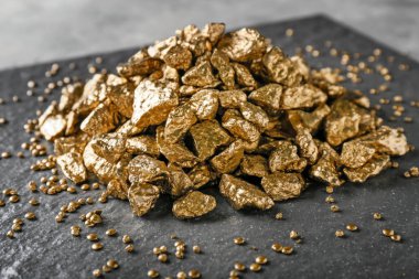 Kayrak plaka üzerinde altın nuggets yığını