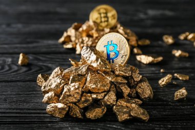 Altın nuggets ve koyu ahşap arka plan üzerinde bitcoins