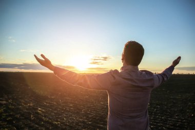 Dindar adam açık havada günbatımında dua