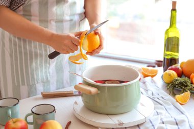 Kadın masada mulled şarap hazırlanıyor