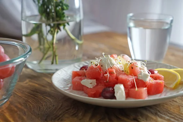 Plaat met heerlijke watermeloen salade op houten tafel — Stockfoto