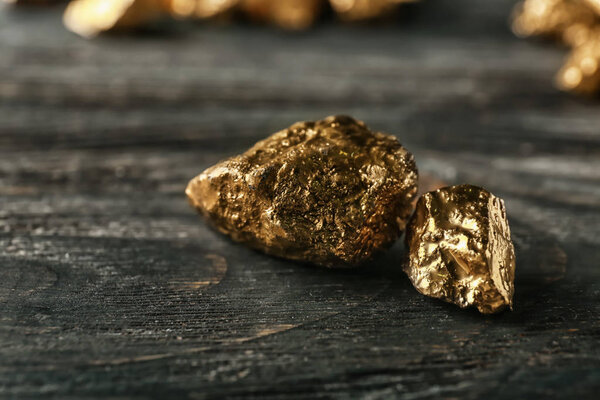 Gold nuggets on dark wooden background