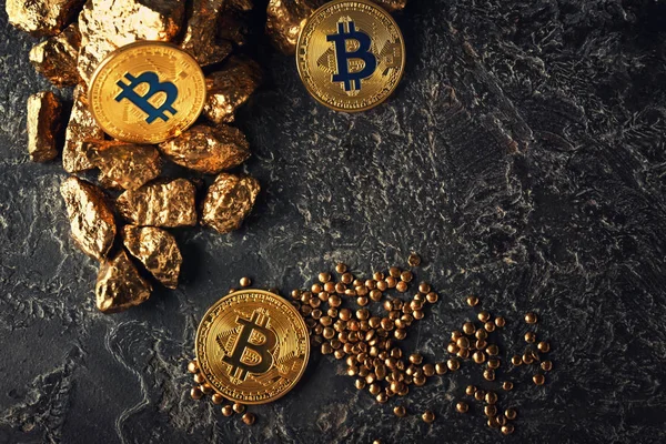 Pepitas de oro y bitcoins sobre fondo oscuro — Foto de Stock