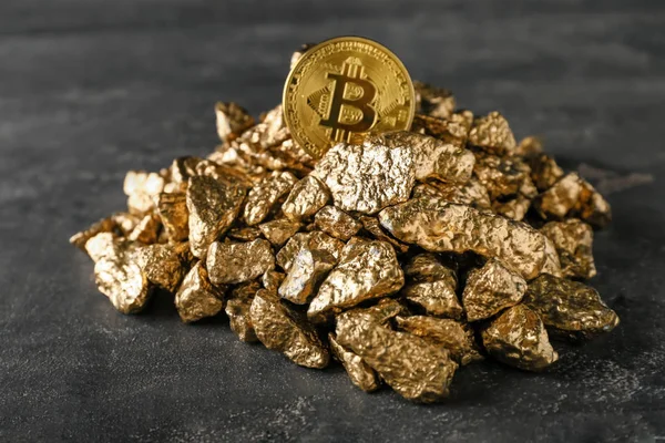 Gold nuggets and bitcoin on dark background — Stock Photo, Image
