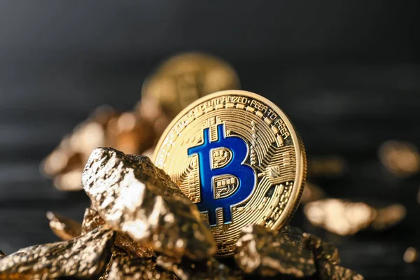 Gold nuggets and bitcoin on dark background, closeup — Stock Photo, Image