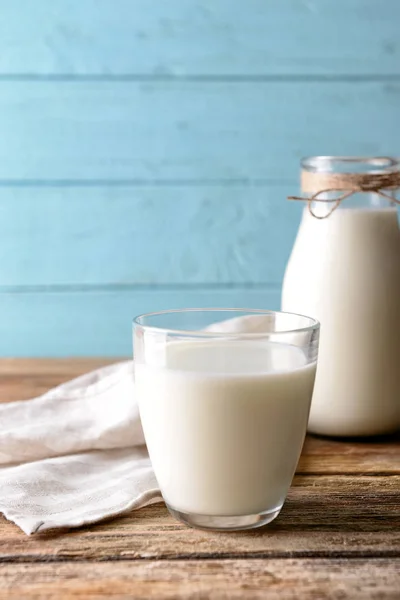 Glas und Flasche Milch auf Holzgrund — Stockfoto
