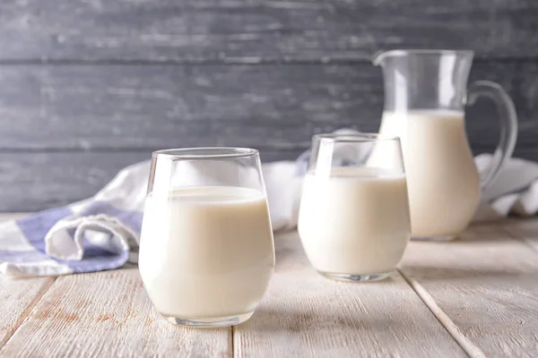 Milchgläser auf Holztisch — Stockfoto