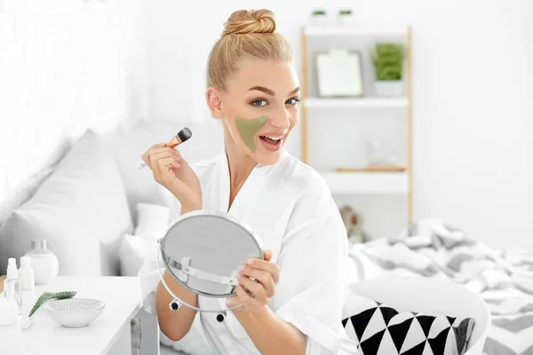 Hermosa mujer joven aplicando mascarilla facial con extracto de aloe vera en casa — Foto de Stock