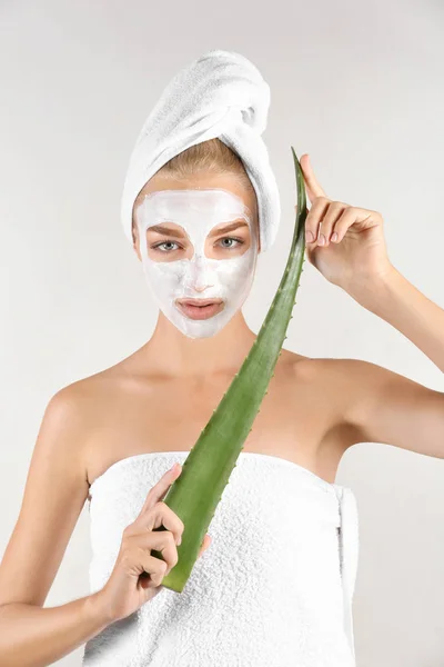 Krásná mladá žena s maska obsahující aloe vera extrakt, na světlé pozadí — Stock fotografie
