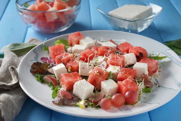 Plaat met heerlijke watermeloen salade op houten kleurentabel, close-up — Stockfoto