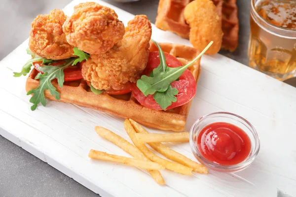 Delicious waffle with chicken, french fries and sauce on wooden board, closeup — Stock Photo, Image