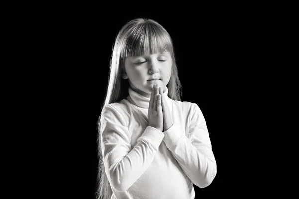 Dívka modlí na tmavém pozadí, černobílý efekt — Stock fotografie