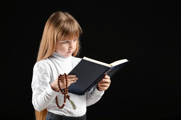 Niña leyendo la Biblia sobre fondo oscuro — Foto de Stock