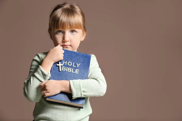 Niña con Biblia sobre fondo de color — Foto de Stock