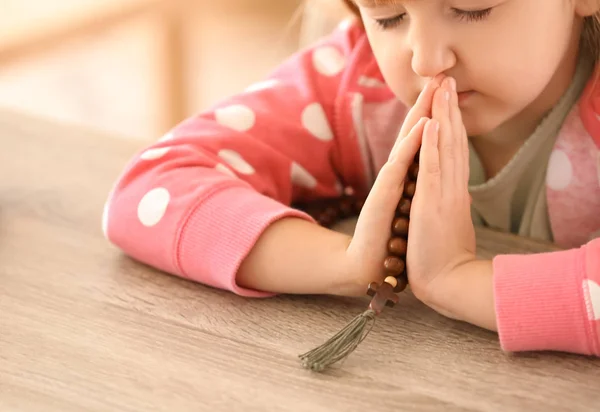 Little girl with beads praying at home — Stock Photo, Image