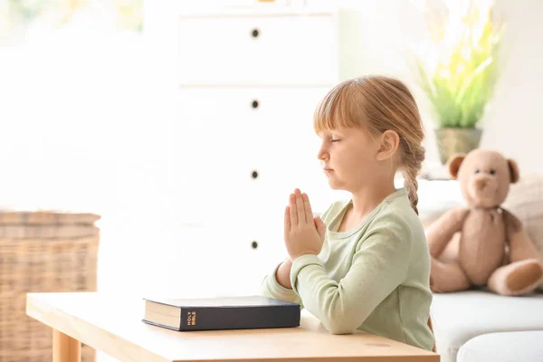 Little girl with Bible praying at home — Stock Photo, Image