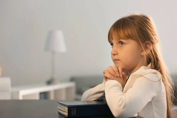 Little girl with Bible praying at home — Stock Photo, Image