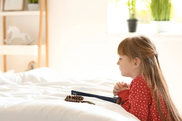 Liten flicka med Bibeln be i sovrum — Stockfoto