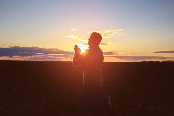 Věřící se modlí venku při západu slunce — Stock fotografie