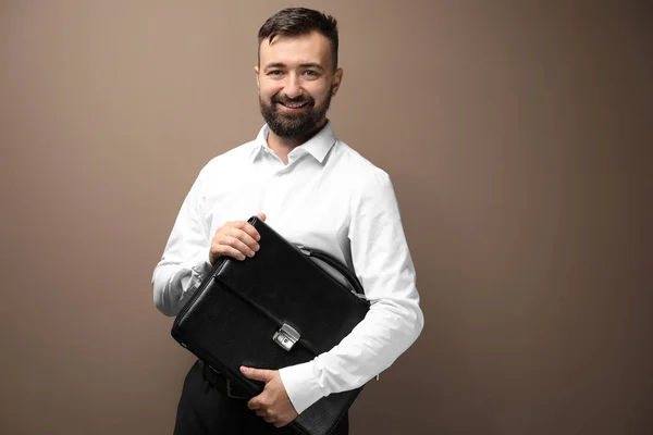 Happy businessman with bag on color background — Stock Photo, Image