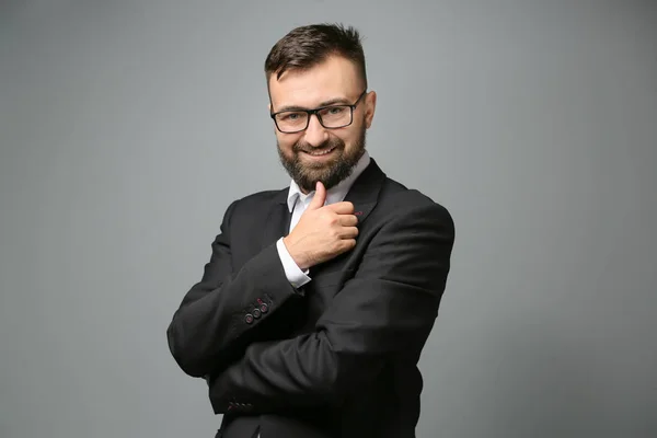 Portrait of handsome businessman on grey background — Stock Photo, Image