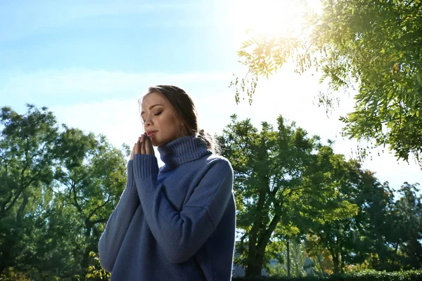 Beautiful young woman praying outdoors — Stock Photo, Image