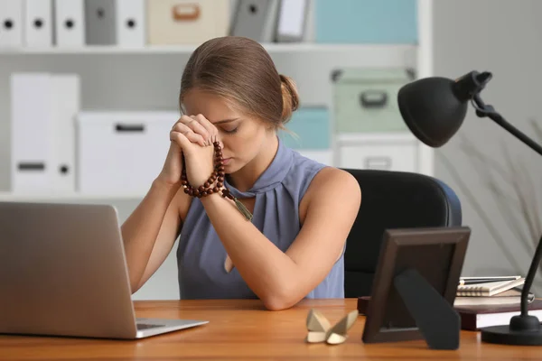 Mooie jonge vrouw bidden in kantoor — Stockfoto