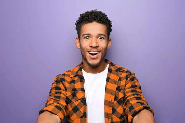 Portrait of surprised African-American man on color background — Stock Photo, Image