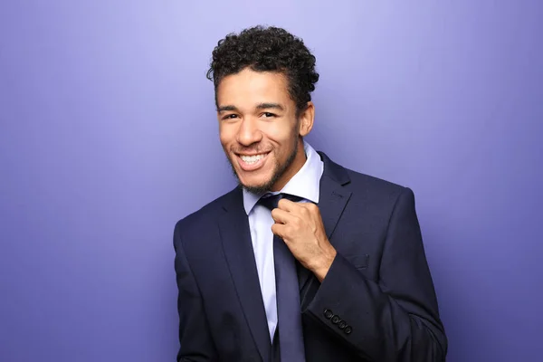 Portrait of handsome African-American businessman on color background — Stock Photo, Image