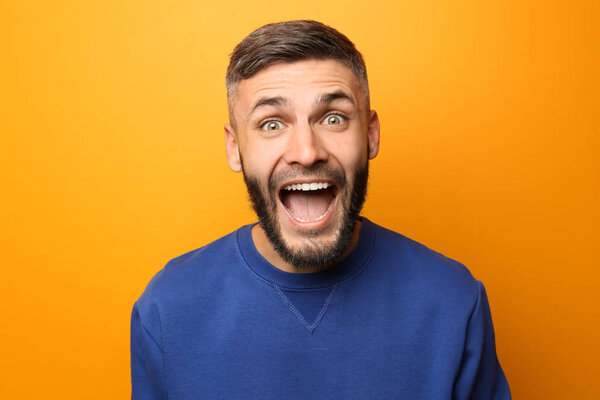 Portrait of excited man on color background