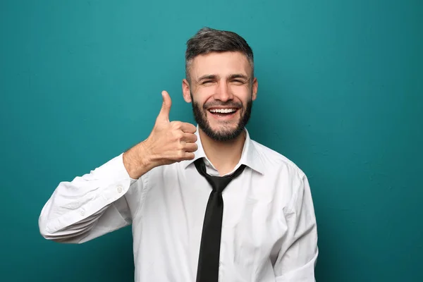 Happy businessman showing thumb-up gesture on color background — Stock Photo, Image