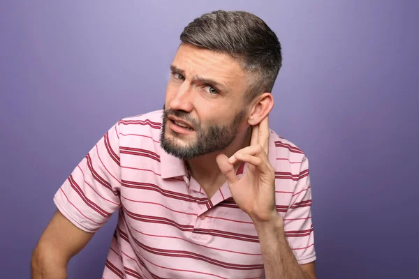 Homem bonito com problema de audição no fundo da cor — Fotografia de Stock