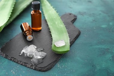 Soyulmuş aloe vera ile yeşil yaprakları ve şişe üzerinde renk tablosu