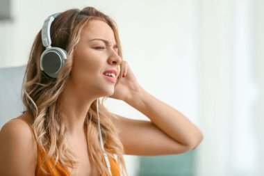 Evde müzik dinleyen güzel genç bir kadın.