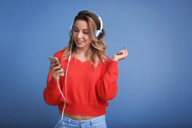 Renkli arka planda müzik dinleyen güzel genç bir kadının portresi