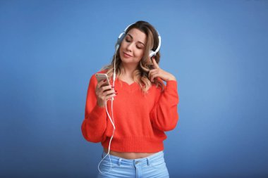 Renkli arka planda müzik dinleyen güzel genç bir kadının portresi