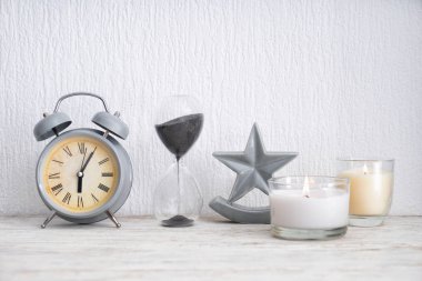 Çalar saat ve kum üzerinde hafif ahşap masa saati ile mumlar yanan güzel