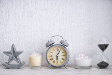 Çalar saat ve kum üzerinde hafif ahşap masa saati ile mumlar yanan güzel