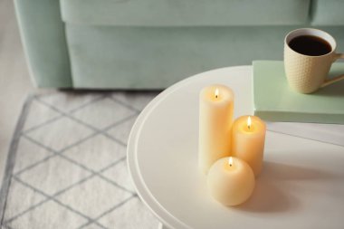 Fincan kahve ve beyaz masa kapalı kitap ile güzel yanan mumlar