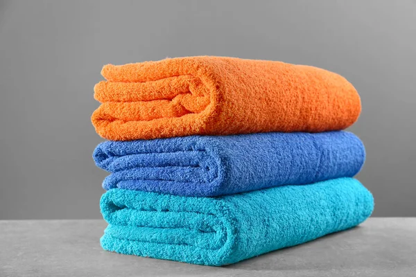 Folded clean towels on grey table — Stock Photo, Image