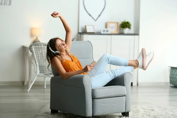 Mooie jonge vrouw luisteren naar muziek thuis — Stockfoto