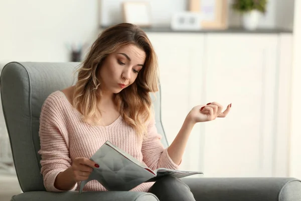 Porträt einer schönen jungen Frau, die zu Hause Magazin liest — Stockfoto