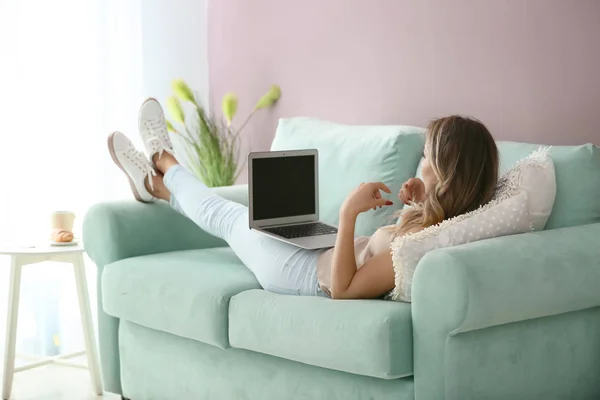 Beautiful young woman with laptop at home — Stock Photo, Image