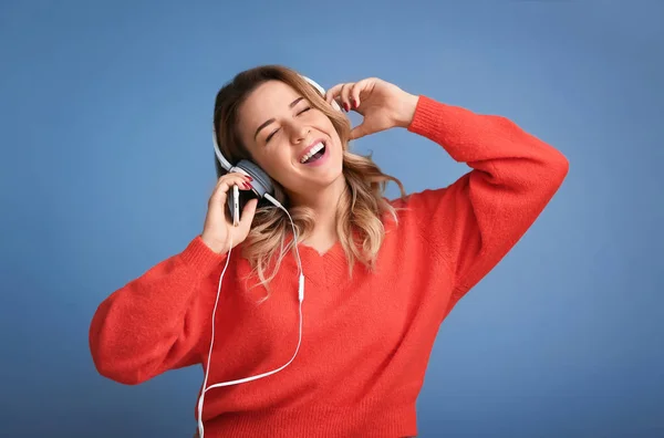 Portrait of beautiful young woman listening to music on color background — Stock Photo, Image